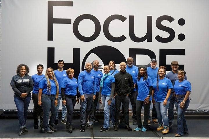 A group of people in blue shirts AI-generated content may be incorrect.