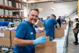 A person in blue uniform smiling at camera AI-generated content may be incorrect.