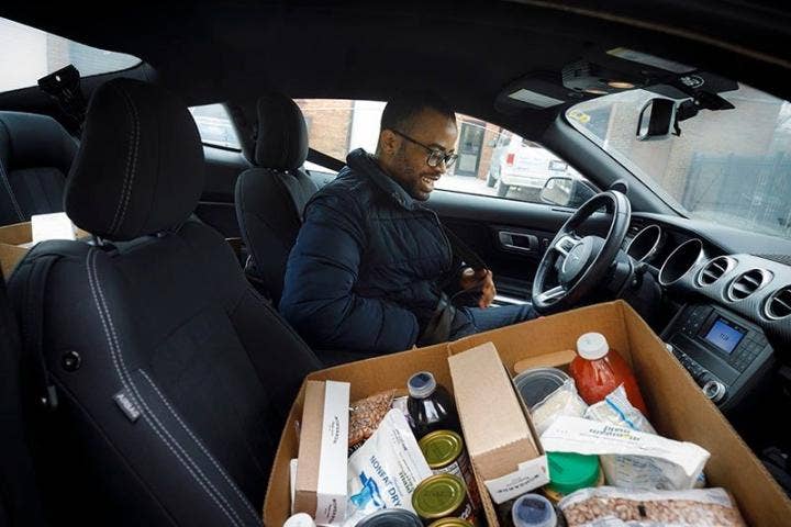 A person in a car with a box of food AI-generated content may be incorrect.