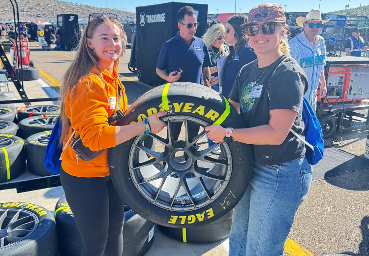 Young techs holding up a NASCAR tire