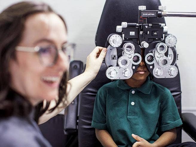 A person looking at a child in an eye exam AI-generated content may be incorrect.