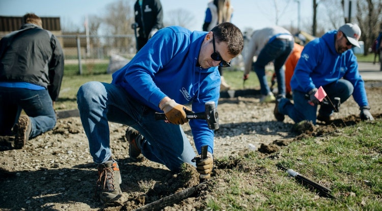 Blue shirt Ford volunteers doing landscaping