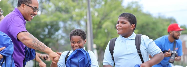Two boys wearing backpacks and standing outside AI-generated content may be incorrect.