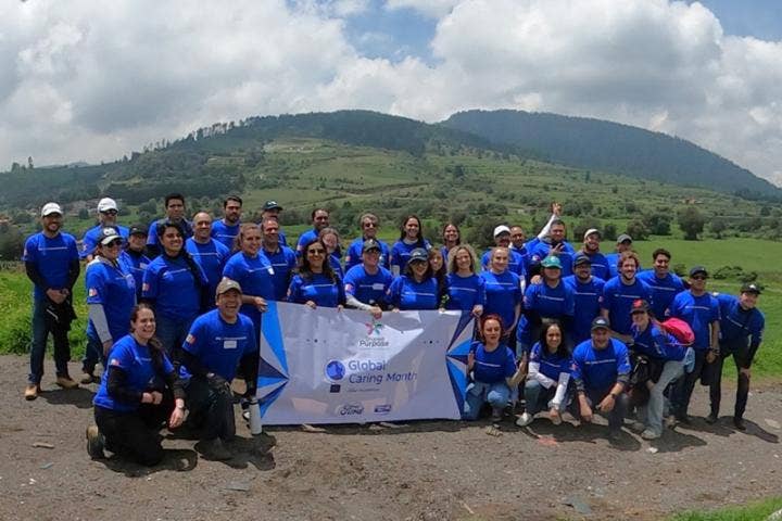 A group of people in blue shirts posing for a photo AI-generated content may be incorrect.